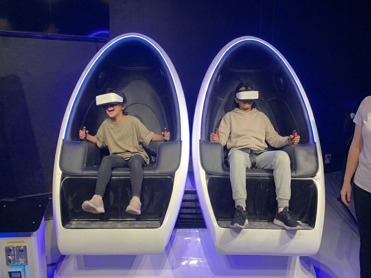 Two children strapped into the 360 VR pods at VR Quest