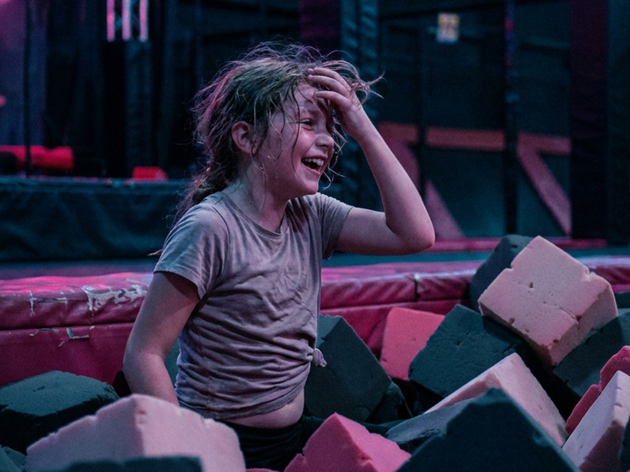 A child laughing in the foam pit at Tru Ninja