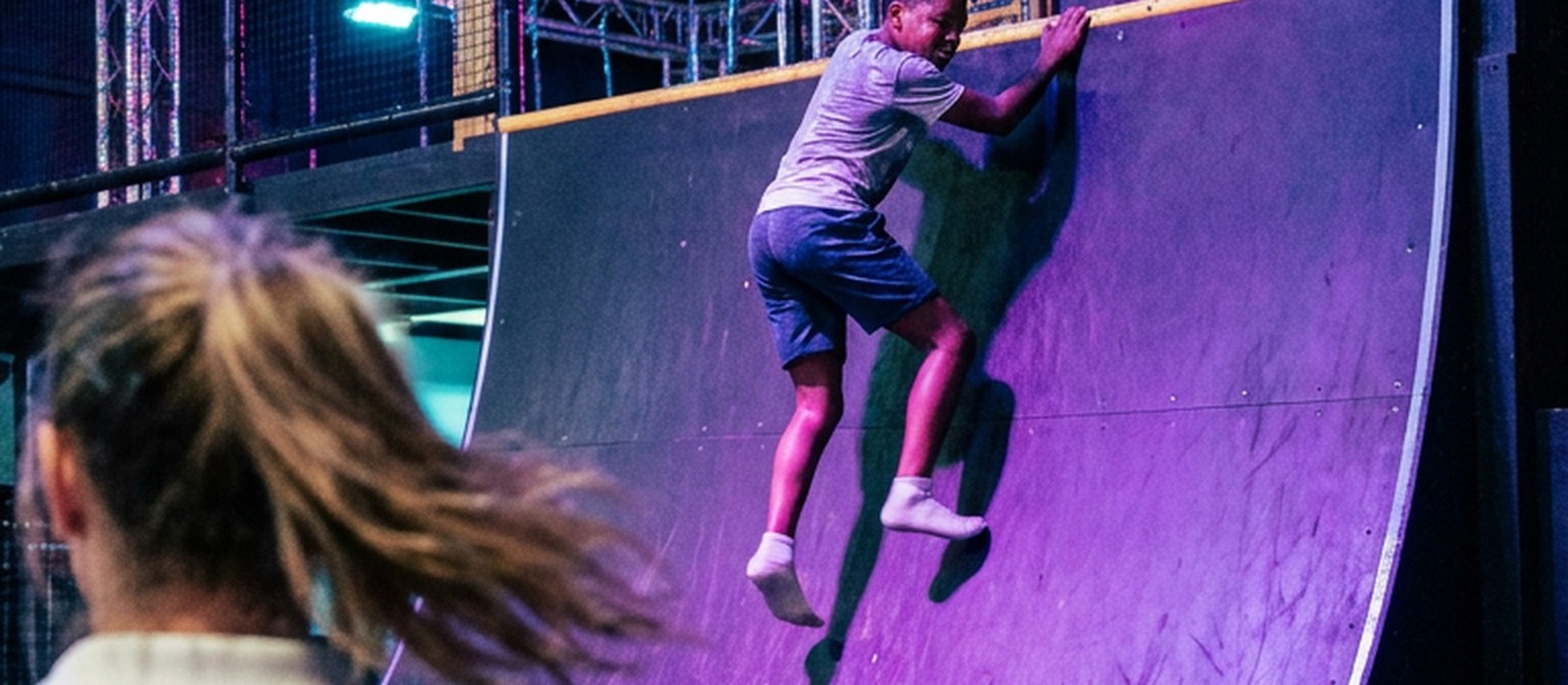 A child climbing the warped wall at Tru Ninja