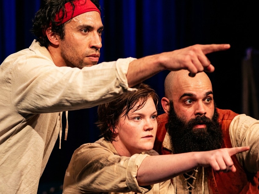 Three pirate performers pointing off stage during the show