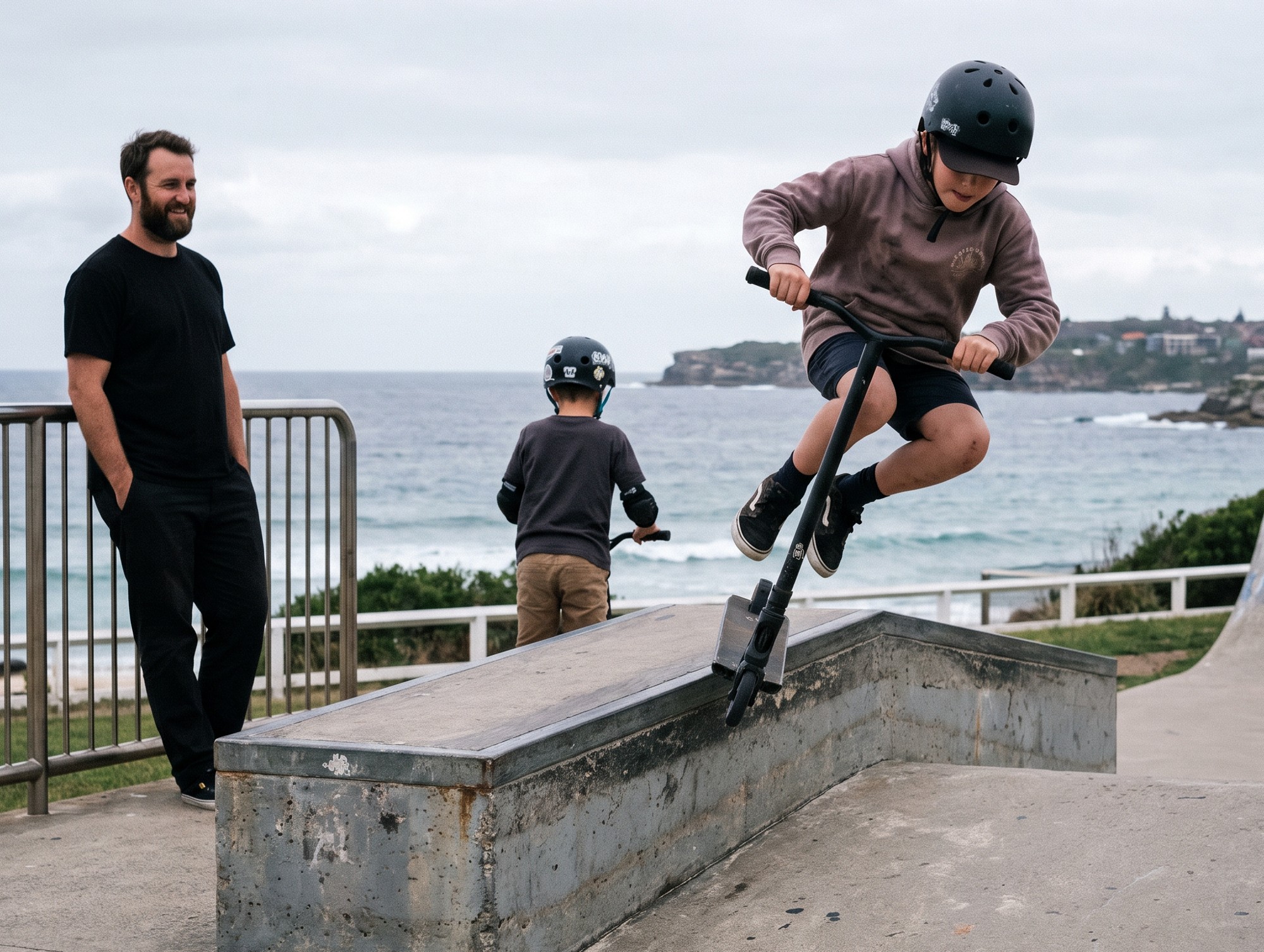 A child riding a scooter at Bondi skate park while a coach watches